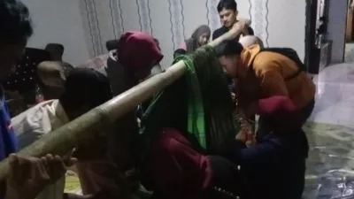 Warga menandu warga sakit sebagai bentuk perjuangan Ramlah demi bertahan hidup di jalan licin.