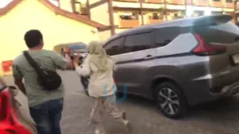 Rahmi Palanna alias Oma Kabur menghindari pertanyaan wartawan usai keluar dari ruang penyidik Tipikor Satreskrim Polresta Gowa. Rabu (15/07/2026)